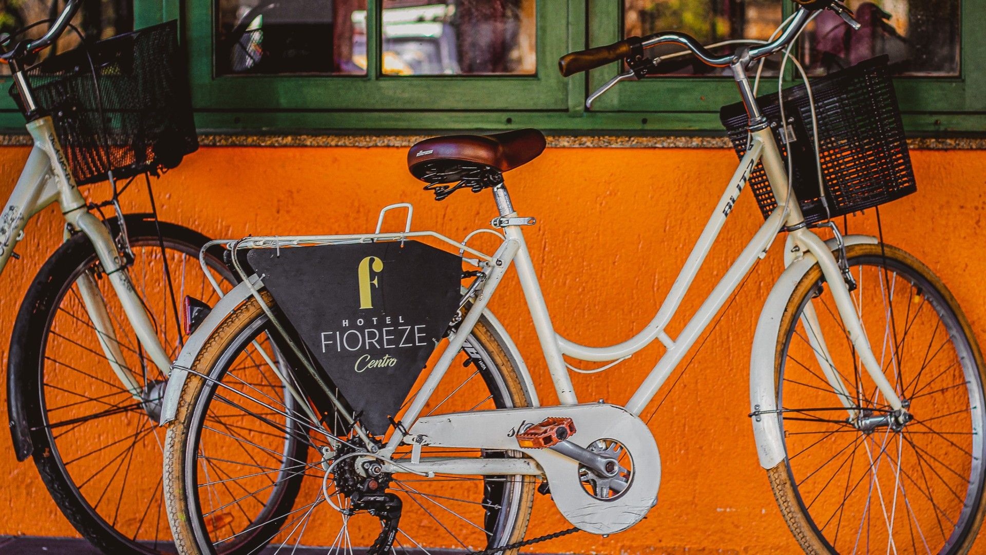 Bicicletas Fioreze estacionadas diante de uma parede laranja