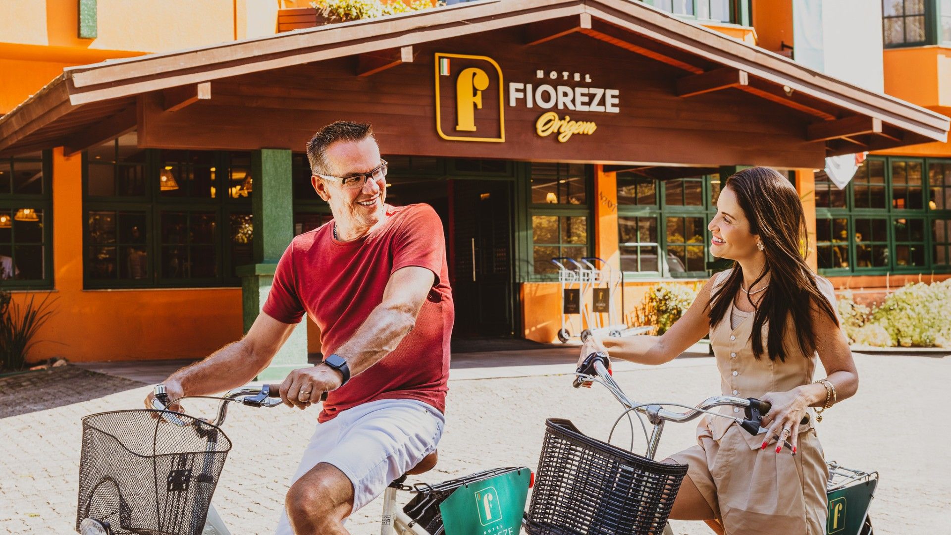 Hóspedes passeiam de bicicleta em frente ao Hotel Fioreze