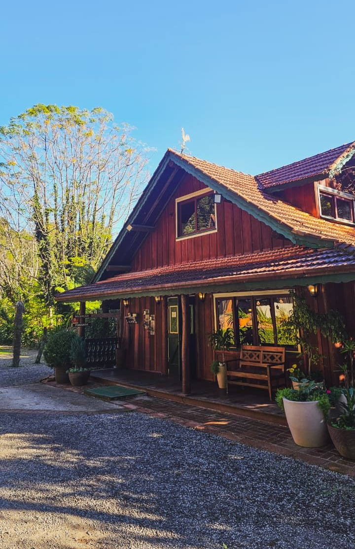 Chalé de madeira entre árvores em Gramado