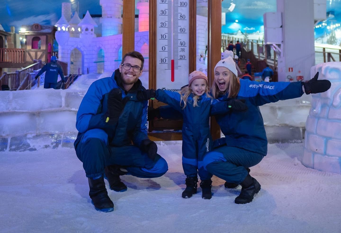 Família com roupas de inverno em um parque de neve coberto