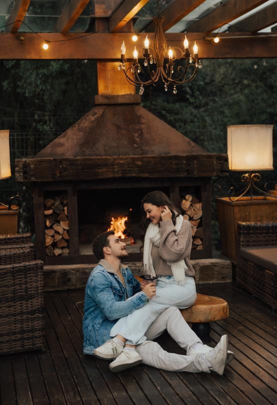 Casal junto à lareira externa do hotel
